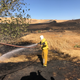 Putting out any remaining fires in the charred grass by the track. Photo credit: Will Faules